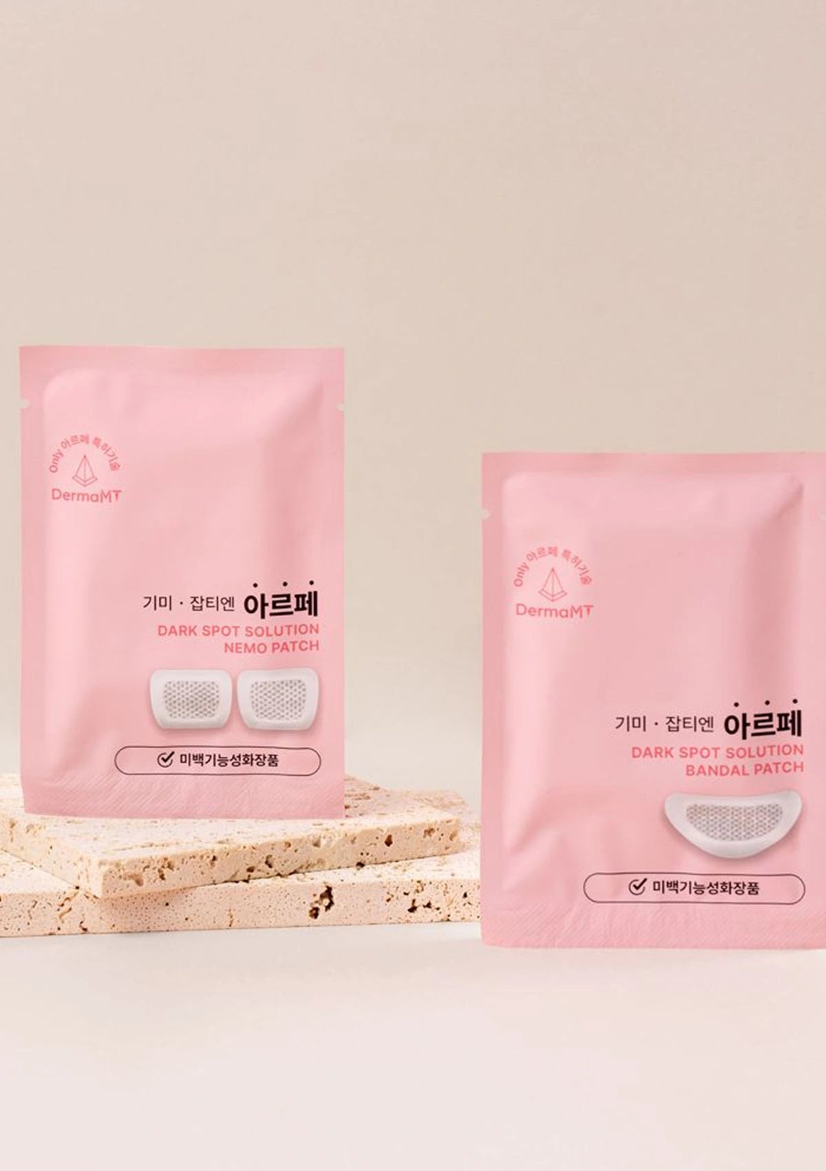 Two pink packages of Derm艾尔芙 dark spot solution patches on a light beige background
